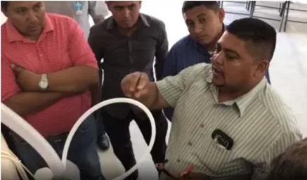 Pastor Ronnie Paz explaining the operation of the M-100 chlorine generator to church members